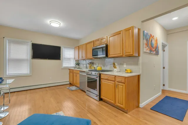 a kitchen with stainless steel appliances granite countertop a stove a sink and a microwave