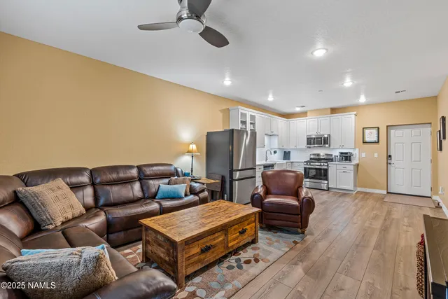 a living room with furniture kitchen and a table