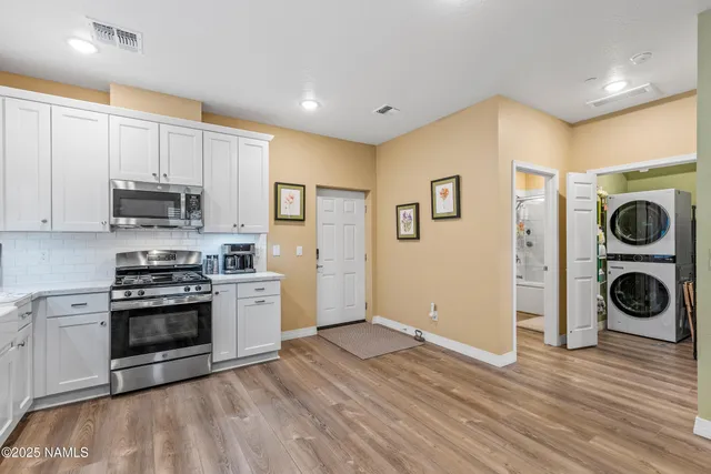 a view of a kitchen with wooden floor and stainless steel appliances