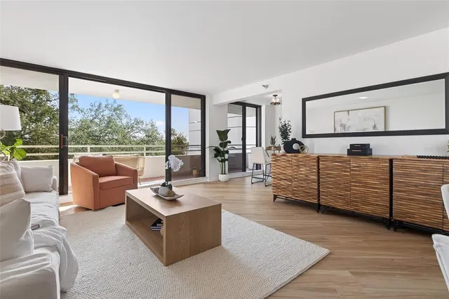 a view of a hallway with wooden floor and furniture