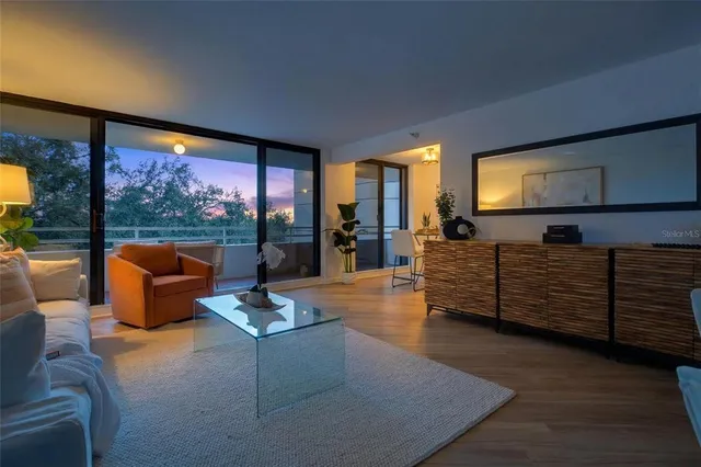 a dining room with furniture a chandelier and wooden floor