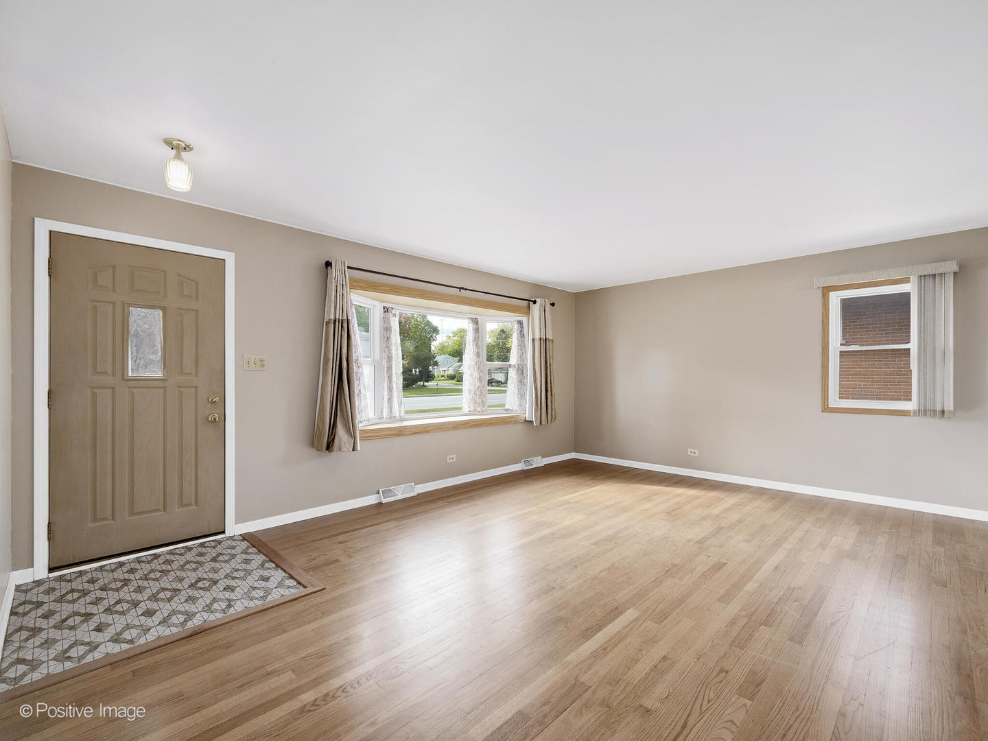5102 Butterfield Road Hillside, IL 60162 - Photo 3 of 22 a view of an empty room with wooden floor and a window