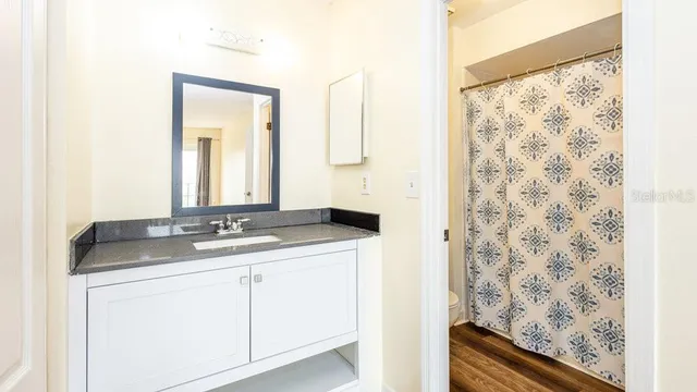 a bathroom with a granite countertop sink and a mirror