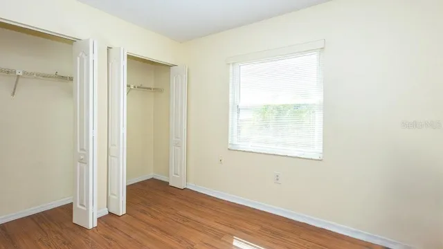 an empty room with wooden floor and a window