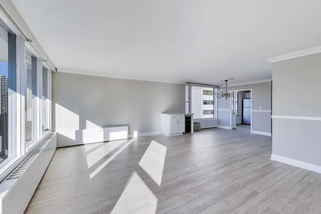 a view of empty room with wooden floor