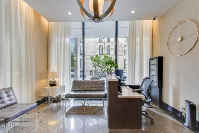 a living room with furniture a large window and a chandelier