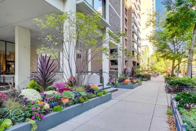 a front view of a multi story residential apartment building with flower garden