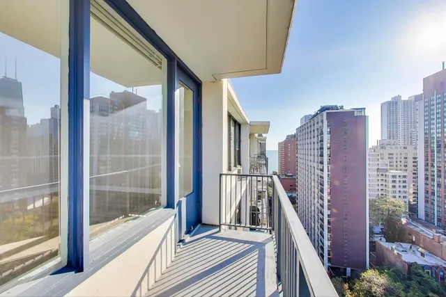 a view of a balcony with wooden floor and fence