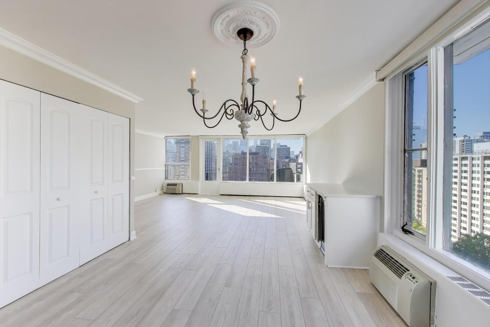 1400 North State Parkway, Unit 18A Chicago, IL 60610 - Photo 8 of 31 a view of a hallway with wooden floor and chandelier