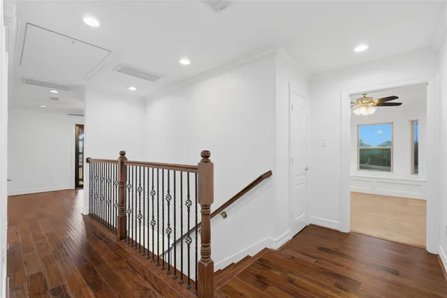 a view of a hallway with wooden floor and stairs