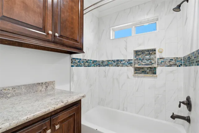 a en suite bathroom with a granite countertop sink and a mirror