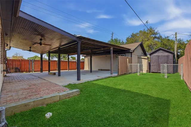 an empty room with windows and chandelier fan