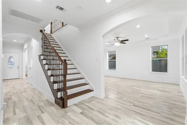 an entryway in a hall with a window and wooden floor