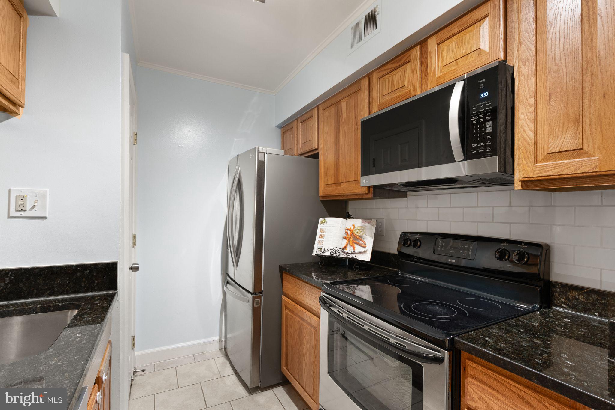 8511 Barrington Court, Unit S Springfield, VA 22152 - Photo 26 of 29 a kitchen with stainless steel appliances granite countertop a stove microwave and refrigerator