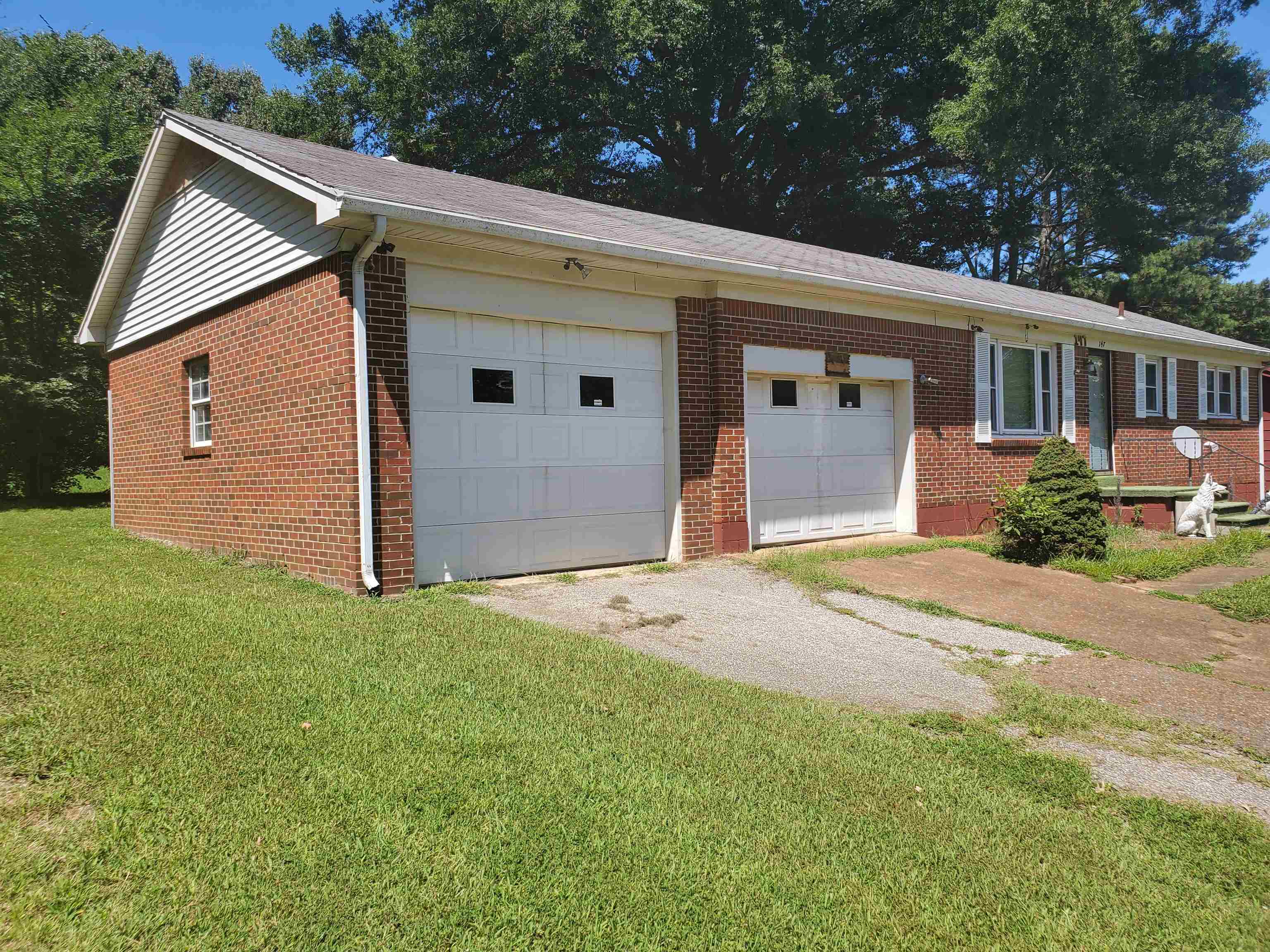 147 Rogers Street Sharon, TN 38255 - Photo 2 of 16 Brick exterior residence featuring two attached garage bays with white doors