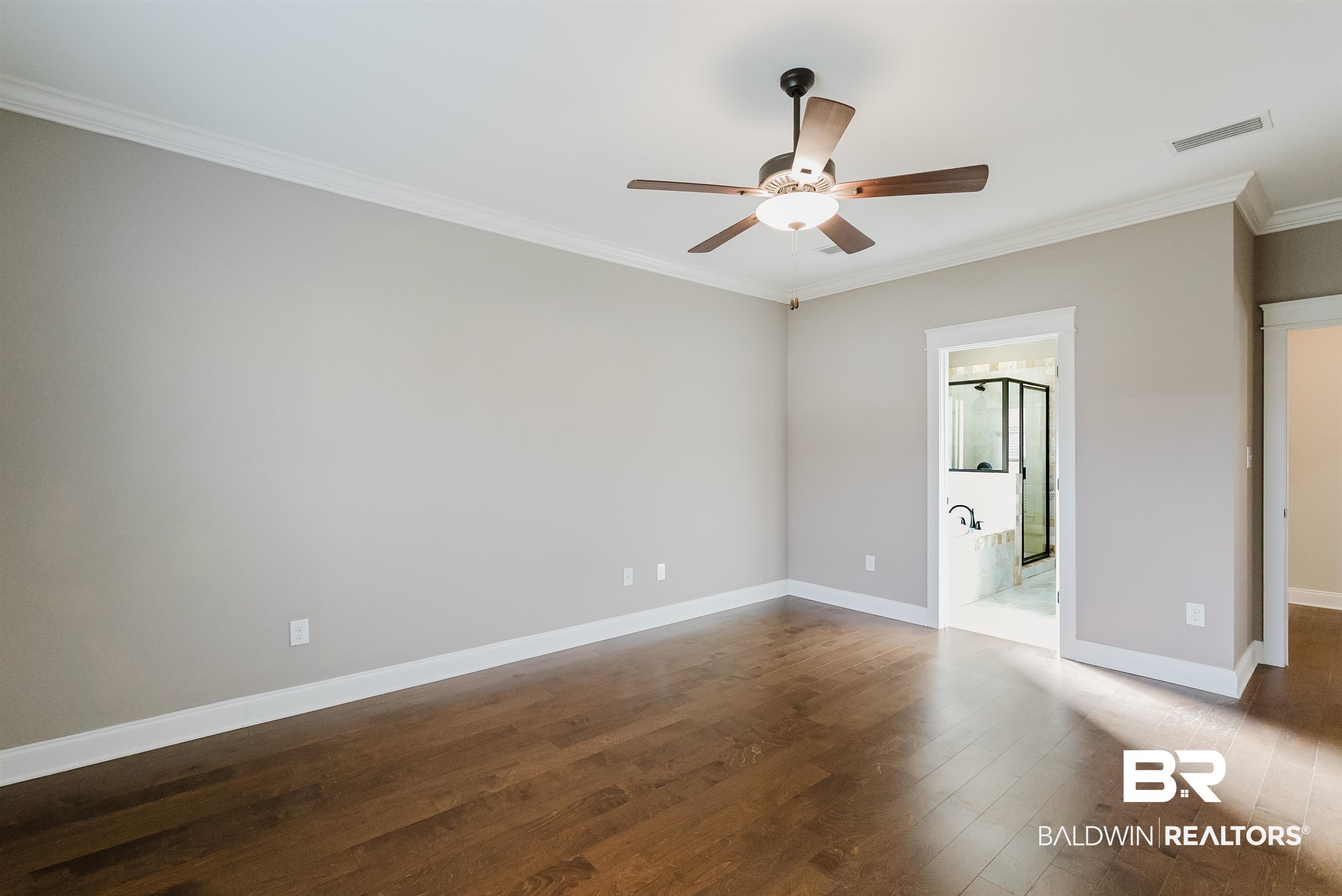237 Hawthorne Circle Fairhope, AL 36532 - Photo 6 of 14 Unfurnished bedroom featuring crown molding, dark wood-type flooring, ceiling fan, and ensuite bathroom