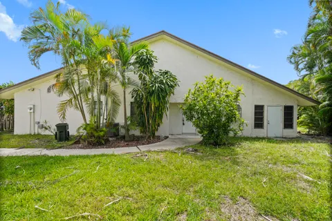 a view of a house with backyard and trees