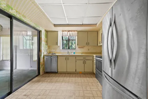 a kitchen with a refrigerator sink and cabinets