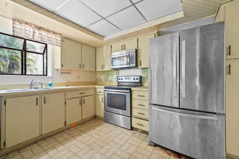 a kitchen with stainless steel appliances a refrigerator sink and cabinets