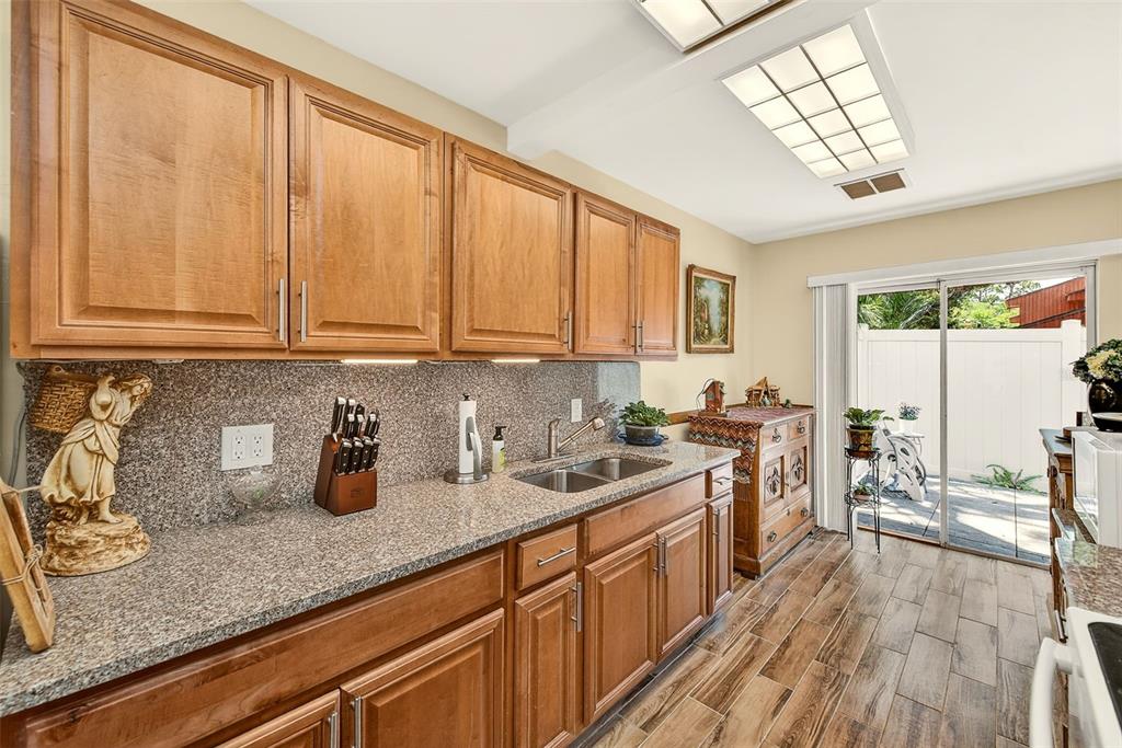 2064 Sunset Point Road, Unit 73 Clearwater, FL 33765 - Photo 16 of 58 a kitchen with sink cabinets and window