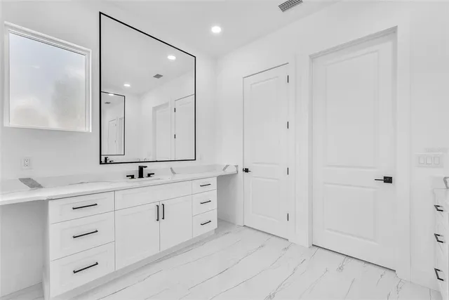 a bathroom with a bathtub sink and mirror
