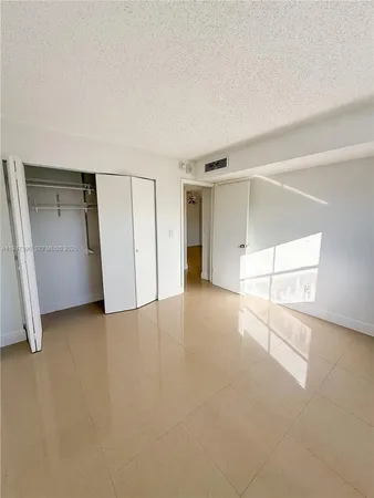 an empty room with closet and windows