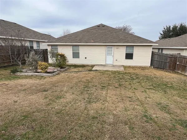 a view of a house with backyard and trees