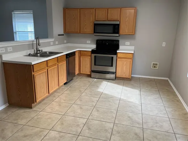 a kitchen with a stove a sink and a microwave