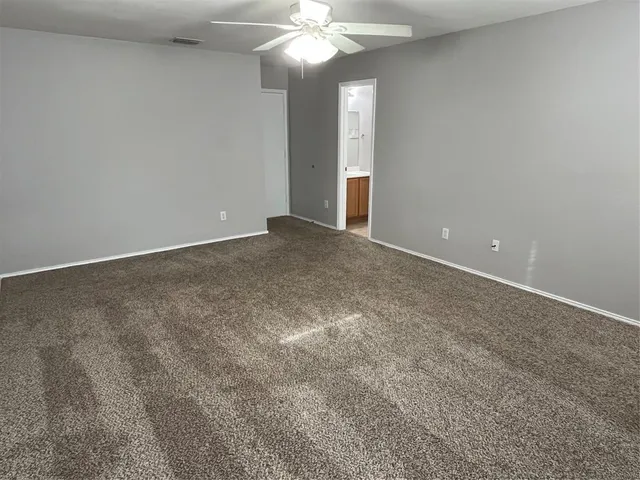 a view of an empty room with a chandelier fan