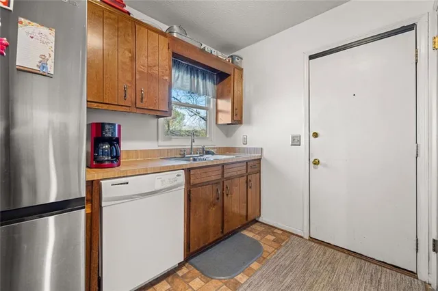 a kitchen with stainless steel appliances a refrigerator sink and cabinets