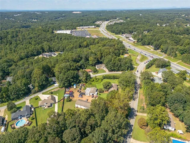 an aerial view of residential houses with outdoor space and trees