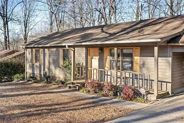 a view of a brick house with large windows and a table and chairs