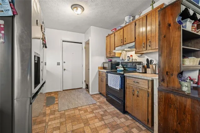 a kitchen with stainless steel appliances granite countertop a refrigerator a stove top oven a sink and dishwasher