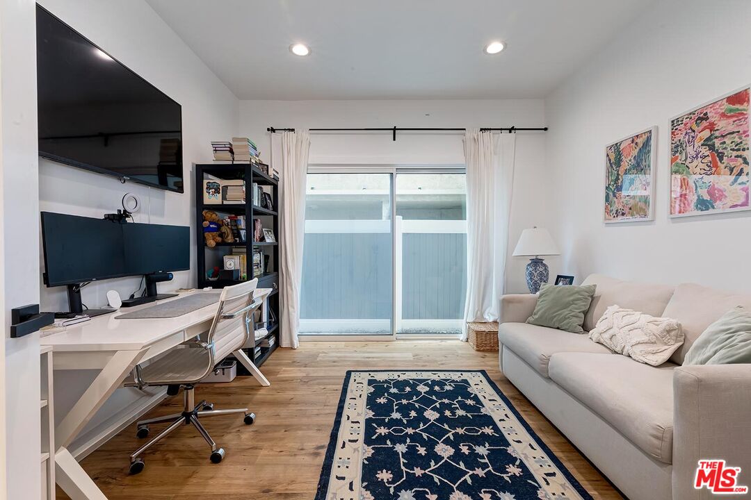 1131 12th Street, Unit 101 Santa Monica, CA 90403 - Photo 16 of 21 a living room with furniture and a flat screen tv