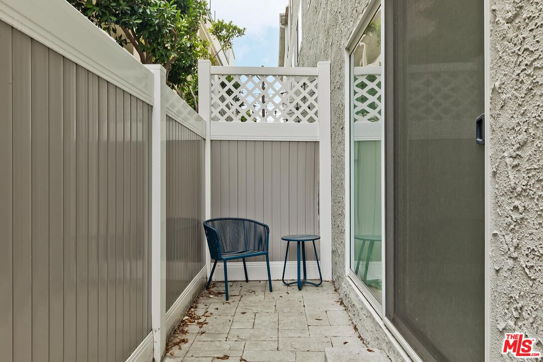 1131 12th Street, Unit 101 Santa Monica, CA 90403 - Photo 17 of 21 a balcony with table and chairs