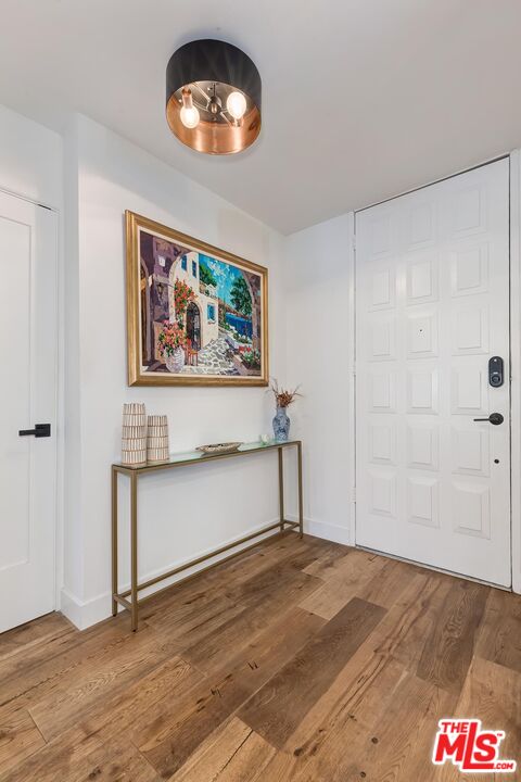 1131 12th Street, Unit 101 Santa Monica, CA 90403 - Photo 20 of 21 a view of an empty room with wooden floor and a window