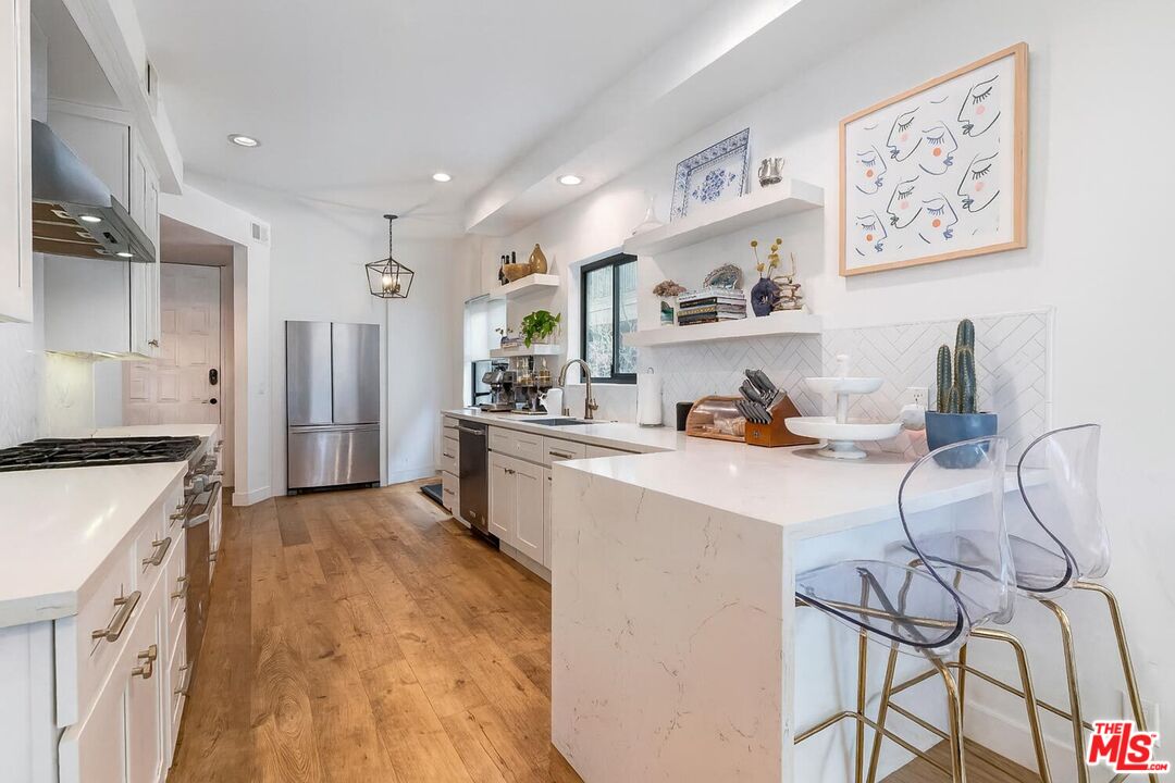 1131 12th Street, Unit 101 Santa Monica, CA 90403 - Photo 9 of 21 a kitchen with stainless steel appliances granite countertop a refrigerator and stove top oven
