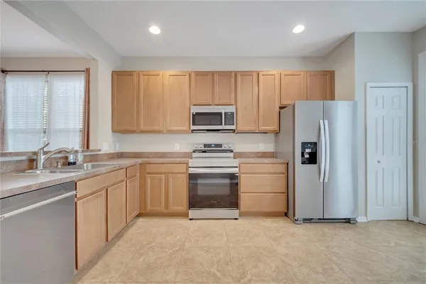 a kitchen with stainless steel appliances granite countertop a refrigerator stove and sink