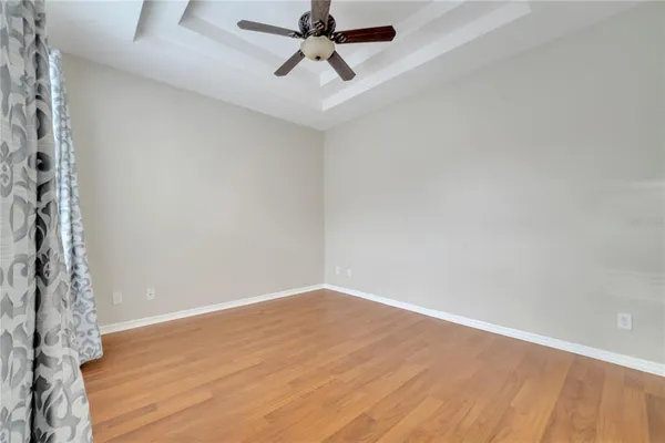 a view of a room with wooden floor and ceiling fan