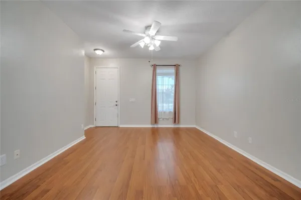 a view of wooden floor and chandelier fan in a room