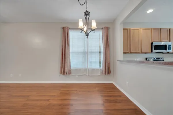 a view of a kitchen with wooden floor and a ceiling fan