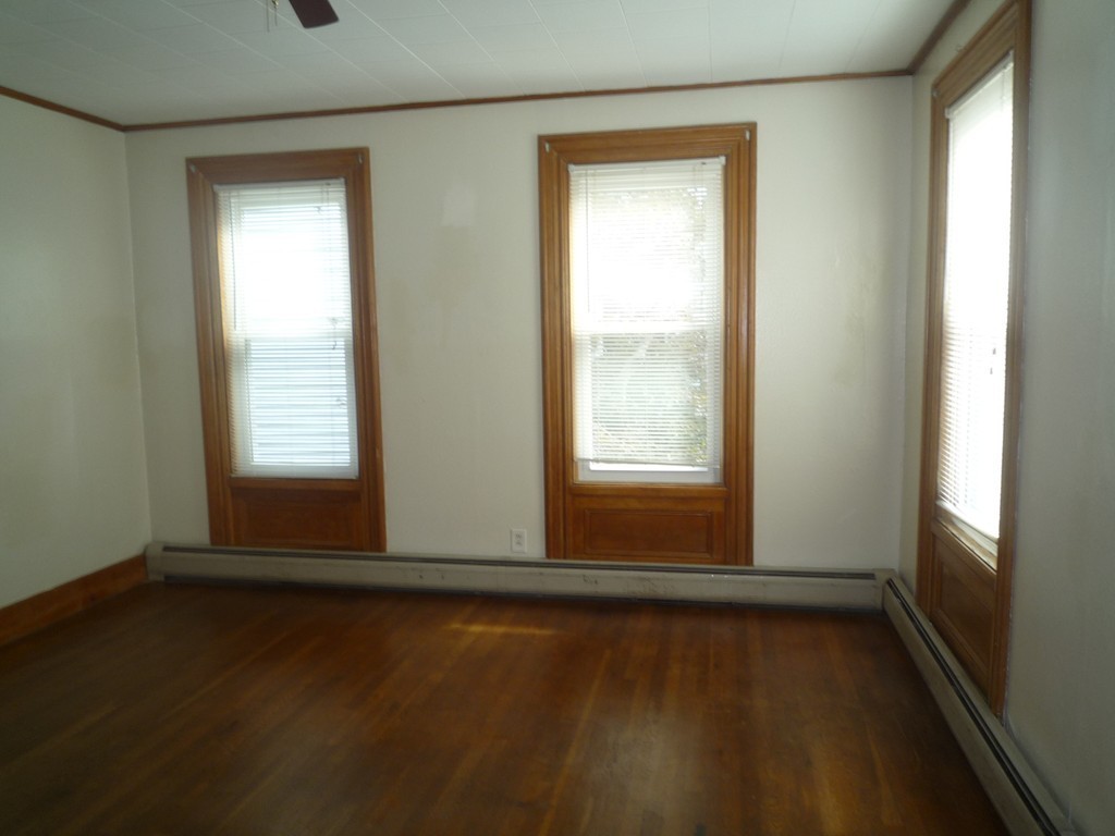 188 Cottage Street Fall River, MA 02721 - Photo 11 of 24 an empty room with wooden floor and windows