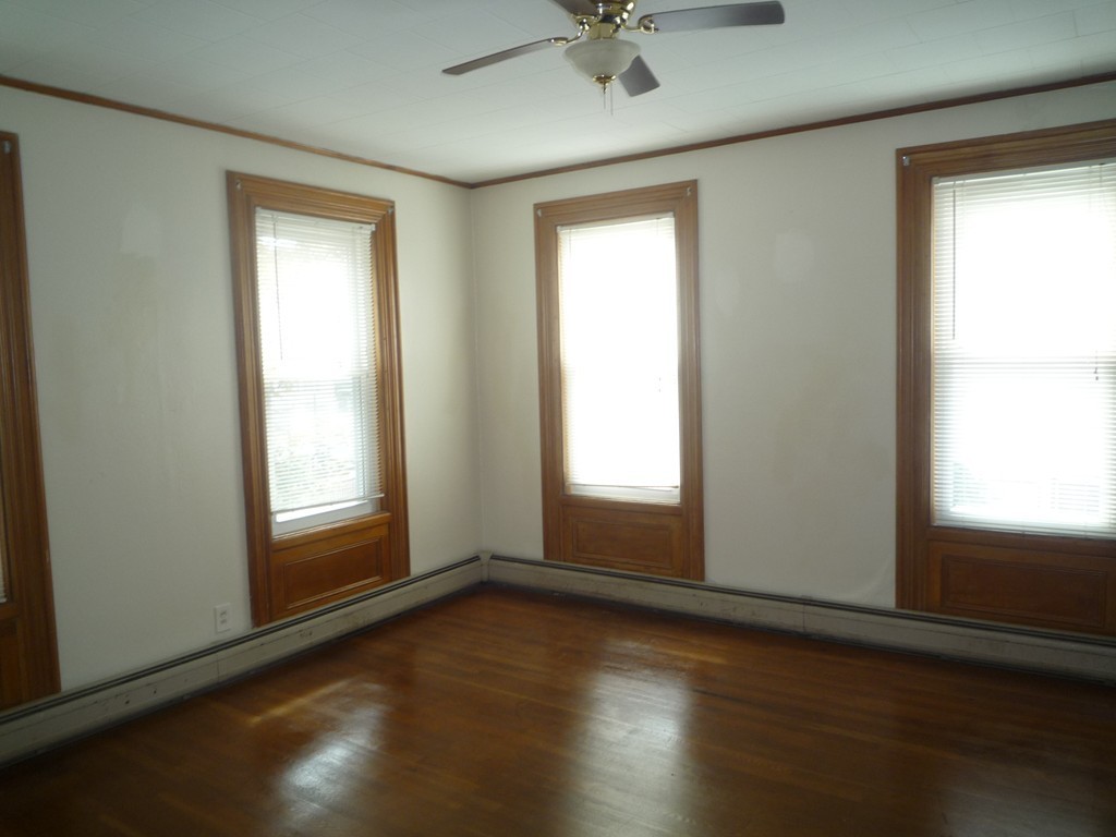 188 Cottage Street Fall River, MA 02721 - Photo 12 of 24 an empty room with wooden floor and windows