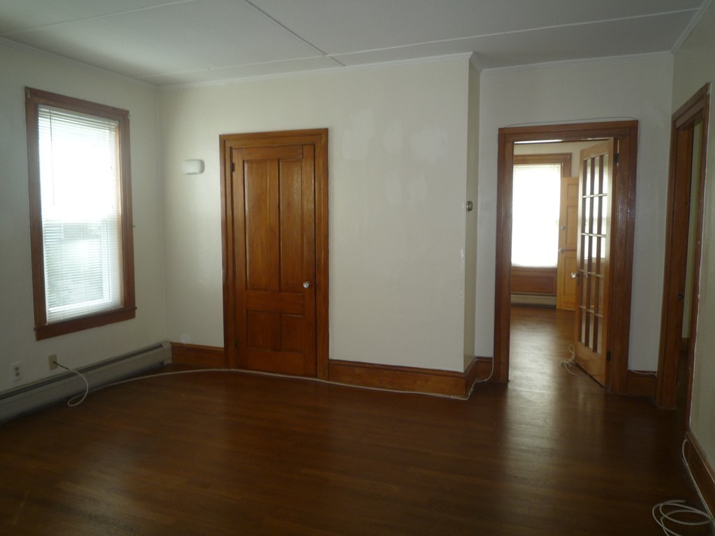 188 Cottage Street Fall River, MA 02721 - Photo 15 of 24 an empty room with wooden floor and windows