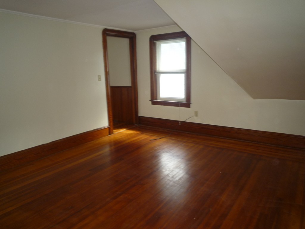 188 Cottage Street Fall River, MA 02721 - Photo 20 of 24 an empty room with wooden floor and windows