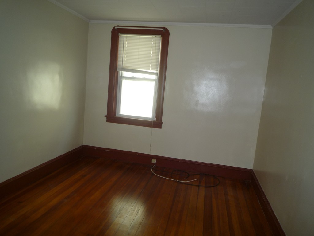 188 Cottage Street Fall River, MA 02721 - Photo 23 of 24 an empty room with wooden floor and windows