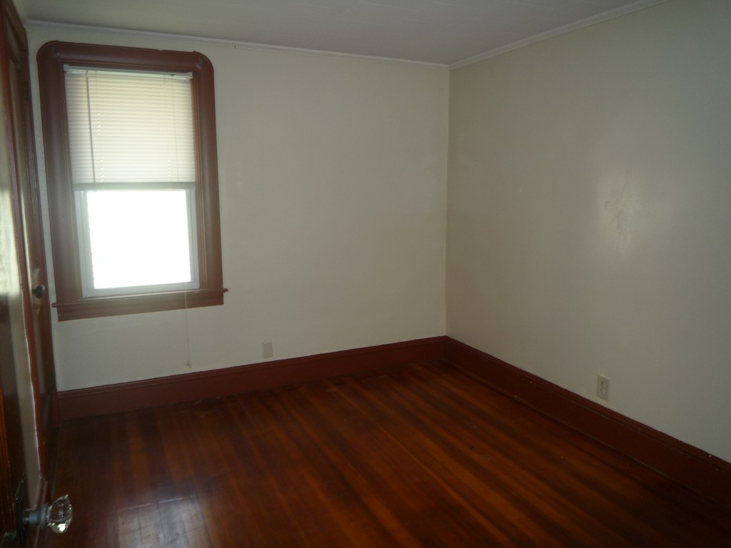 188 Cottage Street Fall River, MA 02721 - Photo 24 of 24 an empty room with wooden floor and windows
