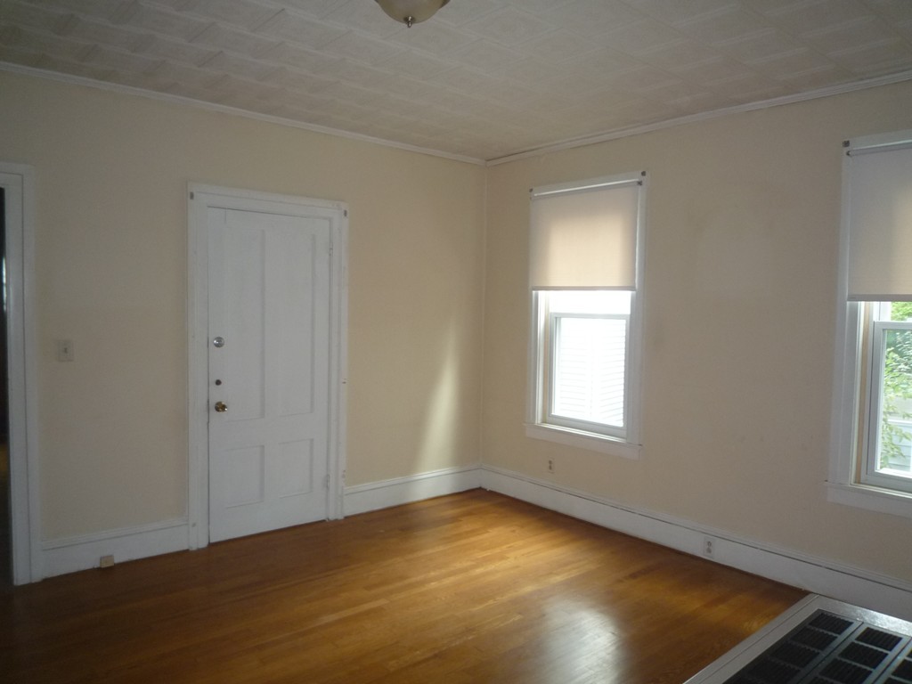 188 Cottage Street Fall River, MA 02721 - Photo 3 of 24 an empty room with wooden floor and windows