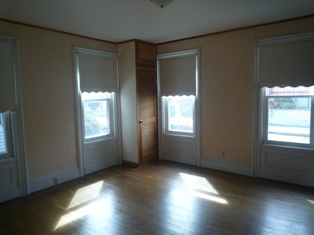 188 Cottage Street Fall River, MA 02721 - Photo 5 of 24 an empty room with wooden floor and windows