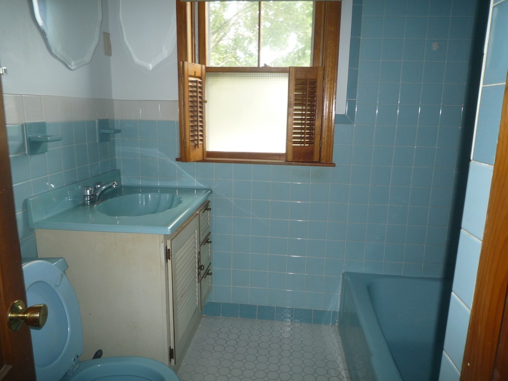 188 Cottage Street Fall River, MA 02721 - Photo 9 of 24 a bathroom with a sink a toilet and a mirror